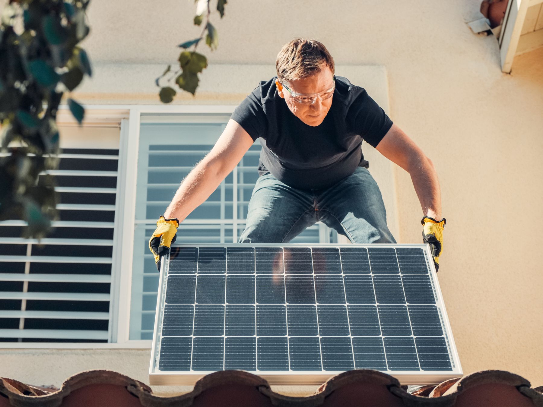 Fachkraft bei der Montage von Photovoltaikmodulen auf einem Dach