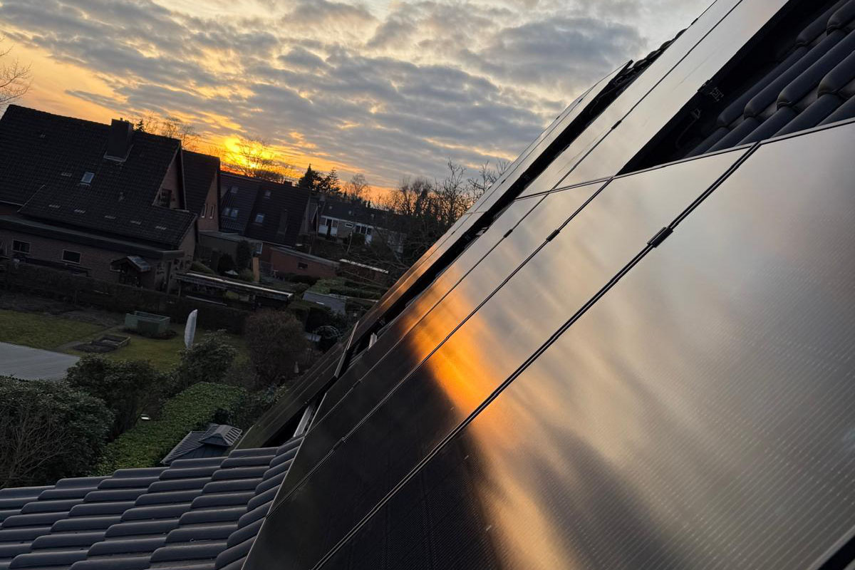 Solarmodule im Abendlicht über einer Wohnsiedlung