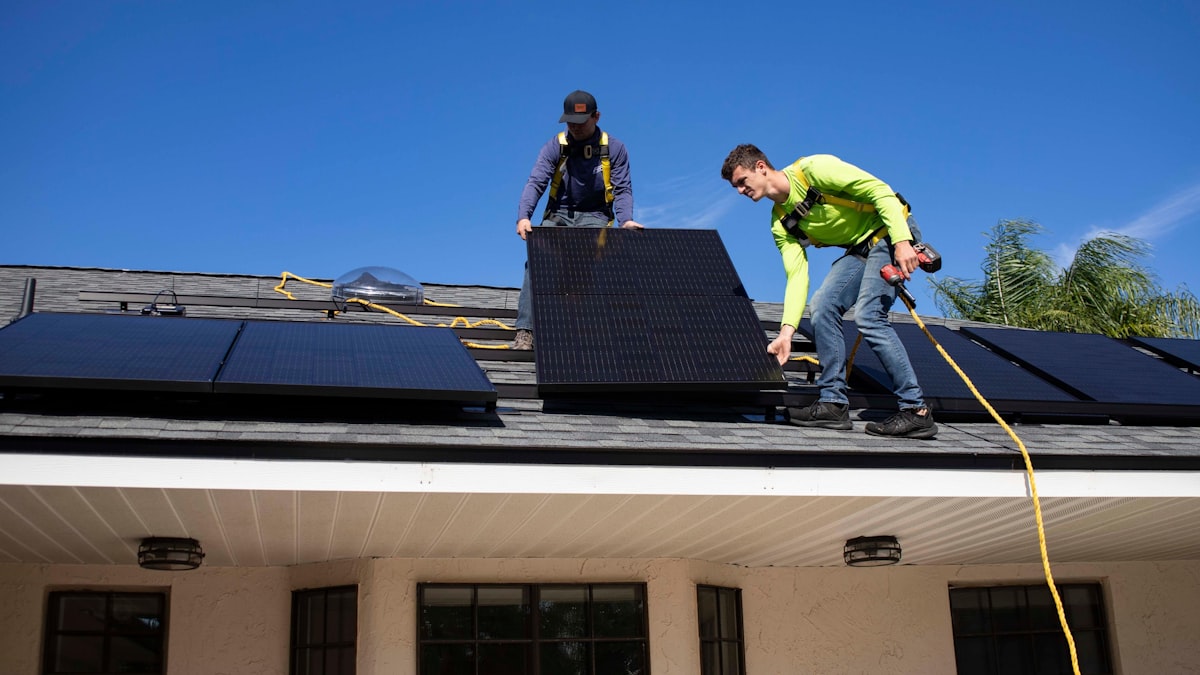Monteure installieren Solarmodule auf einem Dach